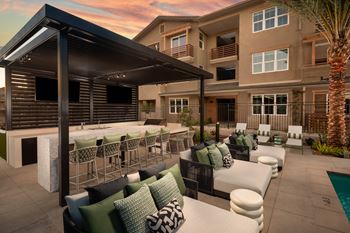 A patio with a fireplace and chairs is set up outside a building.